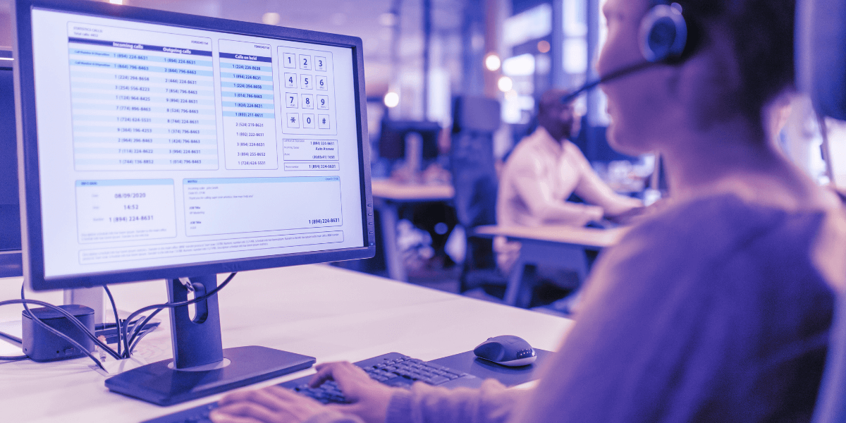 Help desk agent wearing a headset, working at a computer screen with call and support management software displayed, representing managed IT services.